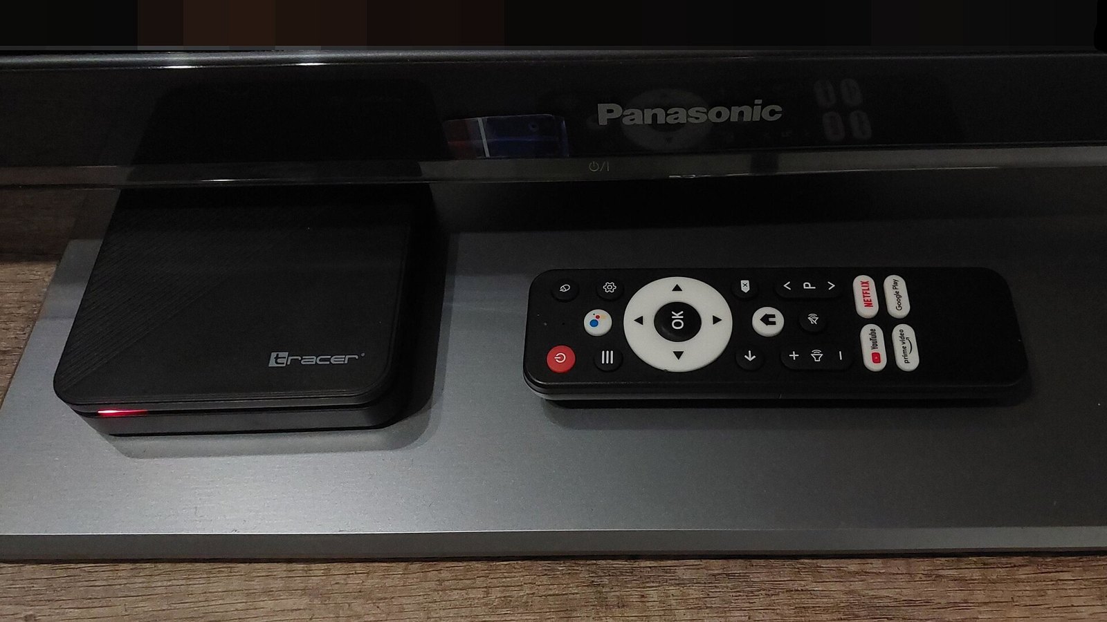 Decodificador Android TV con su control remoto sobre un mueble de televisión