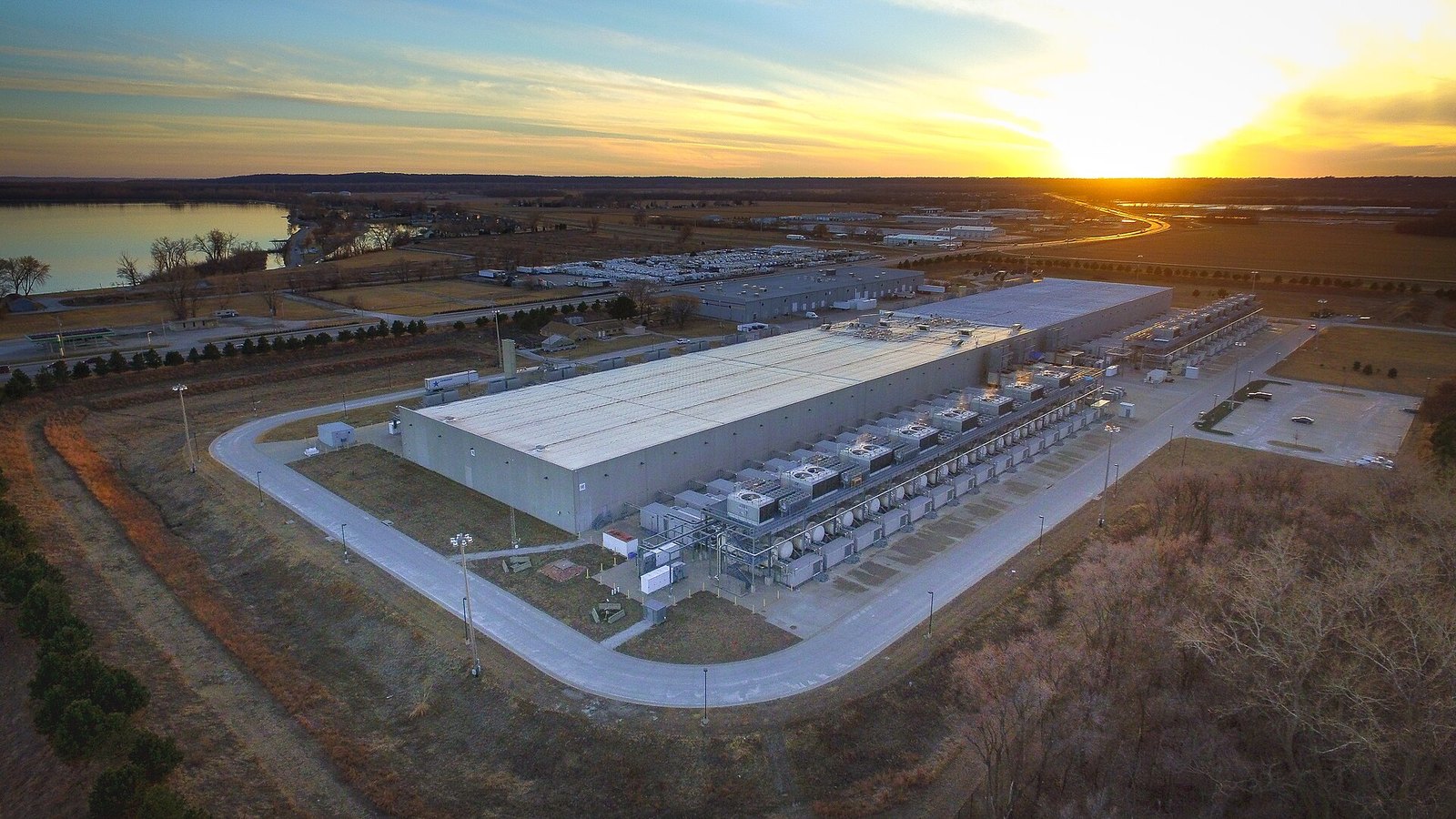 Vista aérea al atardecer de un centro de datos de Google en Council Bluffs, Iowa, con equipos de refrigeración junto a la nave principal